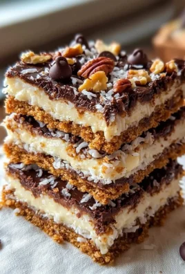 Delicious 7-layer bars with chocolate, coconut, and nuts stacked high.