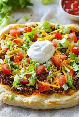 Delicious Crescent Roll Taco Pizza topped with cheese, tomatoes, and taco seasoning