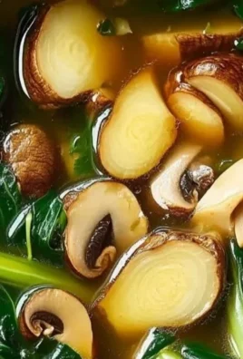 Bowl of savory Bok Choy Soup garnished with green onions and herbs