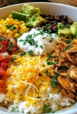 A colorful Chicken Burrito Bowl featuring rice, chicken, beans, and fresh toppings.