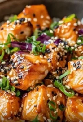 Crispy salmon rice bowl with fresh ingredients and garnishes.