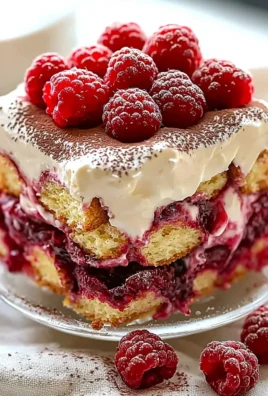 Delicious raspberry tiramisu dessert served on a plate with fresh berries.
