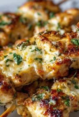 Delicious Garlic Parm Chicken skewers on a wooden platter garnished with herbs.