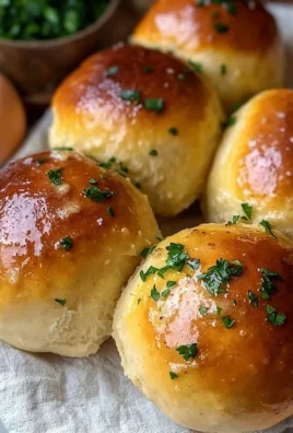 Freshly baked homemade garlic butter dinner rolls on a wooden table