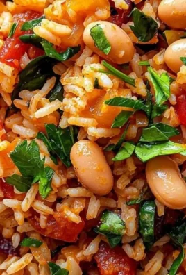 A colorful bowl of Mediterranean Rice and Beans garnished with herbs.