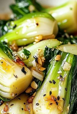Image of sautéed bok choy garnished with garlic and sesame seeds.