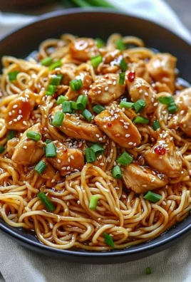Sticky Garlic Chicken Noodles served in a bowl with fresh herbs and vegetables.
