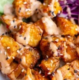 Delicious Bang Bang Tofu served in a bowl, garnished with herbs and sauce