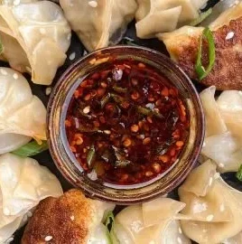 Delicious chicken potstickers, pan fried dumplings served with dipping sauce.