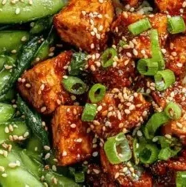 Chili Crunch Tofu Bowls garnished with fresh vegetables and spicy sauce