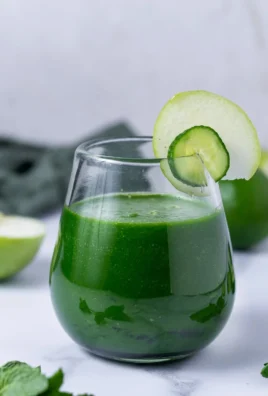 Cucumber apple smoothie in a glass with fresh ingredients