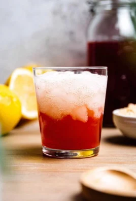 Glass of homemade fermented whey soda with bubbles and fresh ingredients