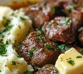 Garlic Parmesan Steak Bites served with mashed potatoes on a plate.