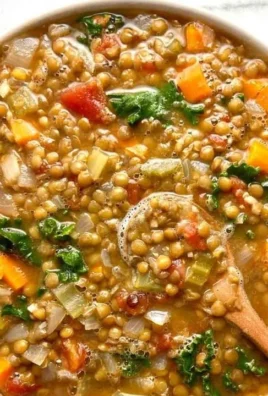 Bowl of healthy lentil soup garnished with herbs and vegetables