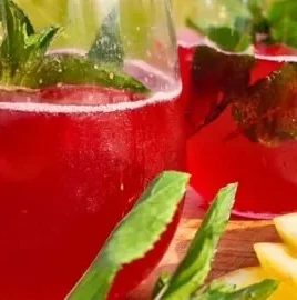 Homemade naturally carbonated hibiscus soda served in a glass with ice