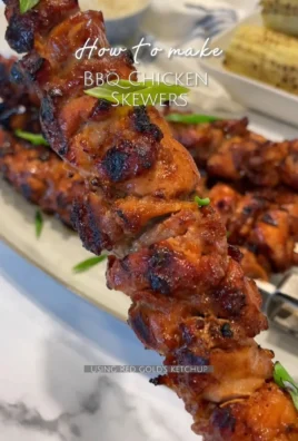 Juicy BBQ chicken skewers on a grill with fresh vegetables