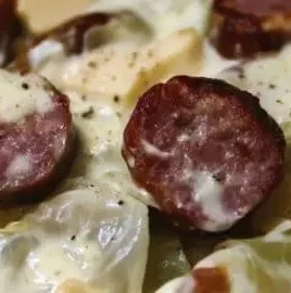 Keto Sausage Cabbage Alfredo dish served in a bowl with fresh herbs.