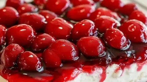 No bake cherry cheesecake dessert topped with cherry filling and whipped cream
