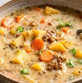Bowl of delicious Vegetarian Lentil Soup with fresh vegetables and herbs