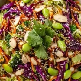 Bowl of Asian Cabbage Salad featuring crunchy sesame ginger slaw garnished with herbs