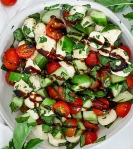 Delicious Caprese salad featuring fresh mozzarella, tomatoes, basil, and cucumbers.