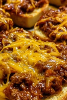 Cheesy Sloppy Joe Garlic Toast served on a plate with fresh herbs