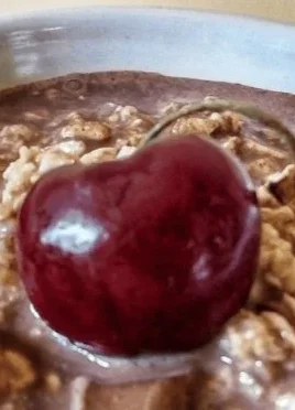 Delicious bowl of Cherry Chocolate Overnight Oats topped with cherries and chocolate.