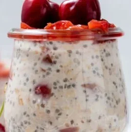 Bowl of cherry overnight oats topped with fresh cherries and almonds