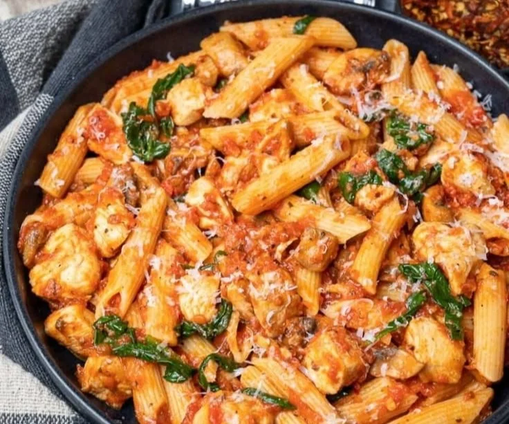 A flavorful dish of Chicken Tomato Pasta topped with fresh herbs.