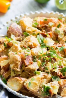 Chipotle Lime Potato Salad with Bacon served in a bowl, garnished with lime wedges.