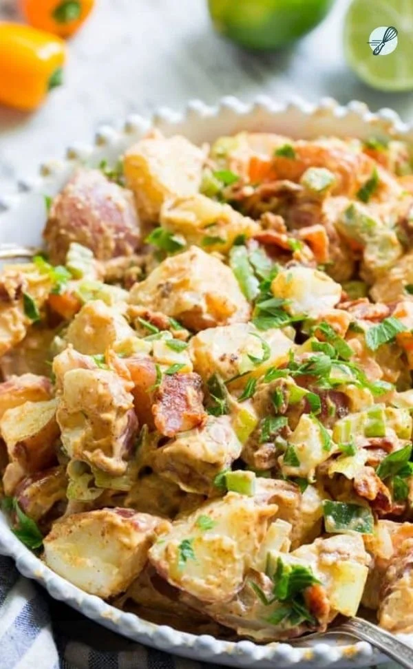 Chipotle Lime Potato Salad with Bacon served in a bowl, garnished with lime wedges.