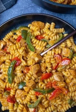 Delicious creamy chicken fajita pasta served in a bowl with colorful peppers.