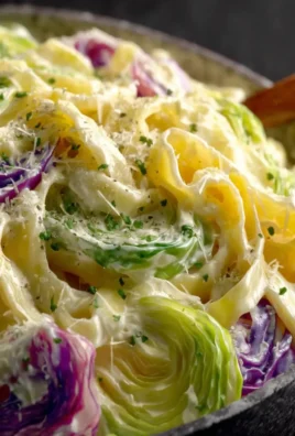 Delicious creamy garlic cabbage fettuccine served in a bowl with fresh herbs.