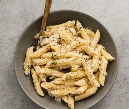 Creamy Garlic Chicken Penne served with a sprinkle of parsley.