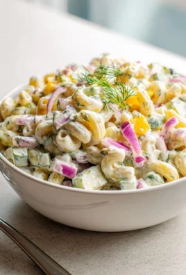 Bowl of Dill Pickle Pasta Salad with cucumbers and dill garnish