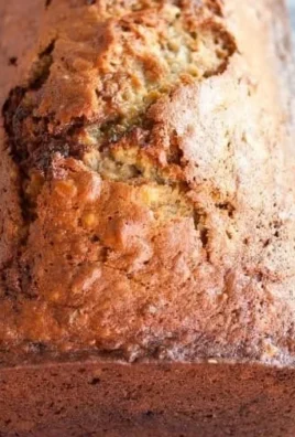 Loaf of easy homemade banana bread on a wooden cutting board