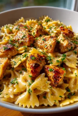 Creamy garlic butter chicken over bowtie pasta served in a bowl