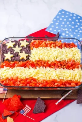 A vibrant Flag Taco Dip with layers of beans, guacamole, and cheese served in a flag design.