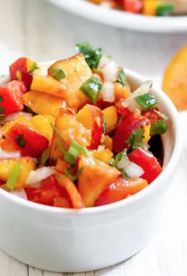 Bowl of fresh peach salsa with diced peaches and colorful vegetables