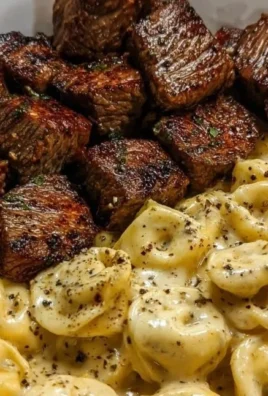 Delicious Garlic Butter Steak Bites served with creamy Alfredo tortellini on a plate