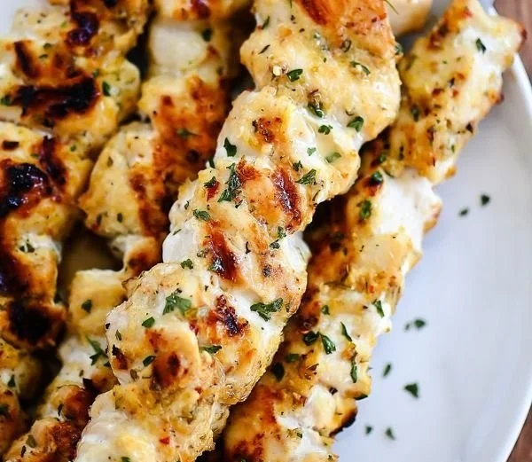 Grilled Garlic Parmesan Chicken Kebabs on a plate with herbs