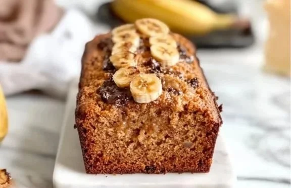 Slice of Greek Yogurt Banana Bread on a wooden table