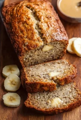 High protein banana bread loaf with sliced pieces on a wooden table