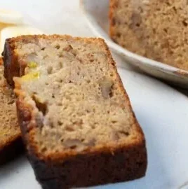 A slice of indulgent olive oil banana bread with a golden crust and chocolate chips