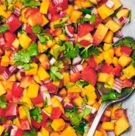 Fresh homemade Peach Mango Salsa with colorful fruits and herbs