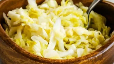 Homemade raw sauerkraut in a glass jar, showcasing its vibrant colors and natural fermentation.