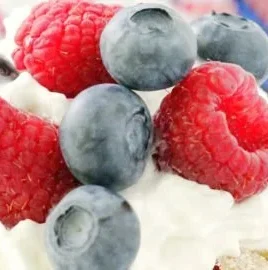 Delicious Red White and Blue Berry Cake topped with fresh strawberries, blueberries, and whipped cream.