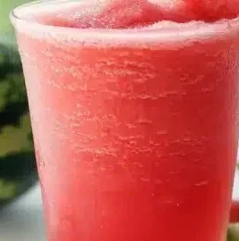 Refreshing watermelon slushie in a glass with ice and mint garnish