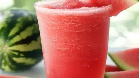 Refreshing watermelon slushie in a glass with ice and mint garnish