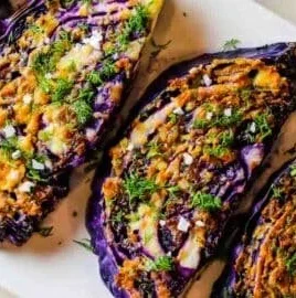 Roasted red cabbage steaks topped with garlic and parmesan cheese